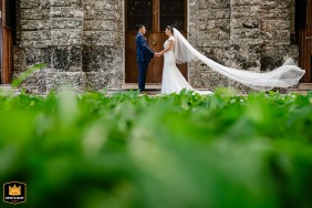 Bride and groom standing face to face, holding hands with the bride’s veil flowing, at a Mexican hacienda in Merida, Yucatan.